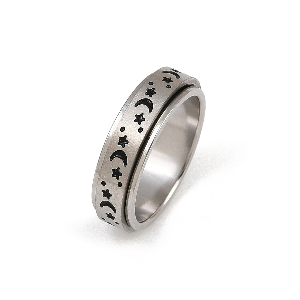 Silver coloured ring with star and moon designs on a white background